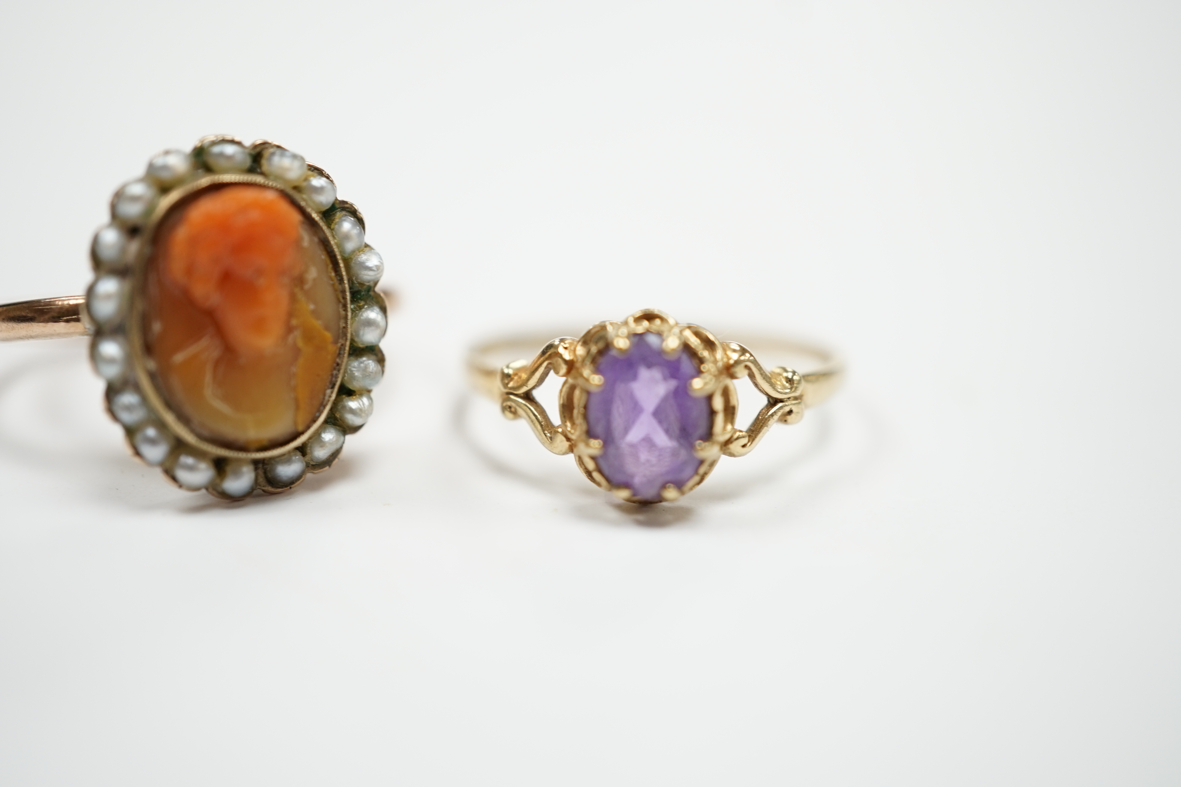A modern 9ct gold and single stone amethyst set ring and a yellow metal, carved coral and split pearl set ring.